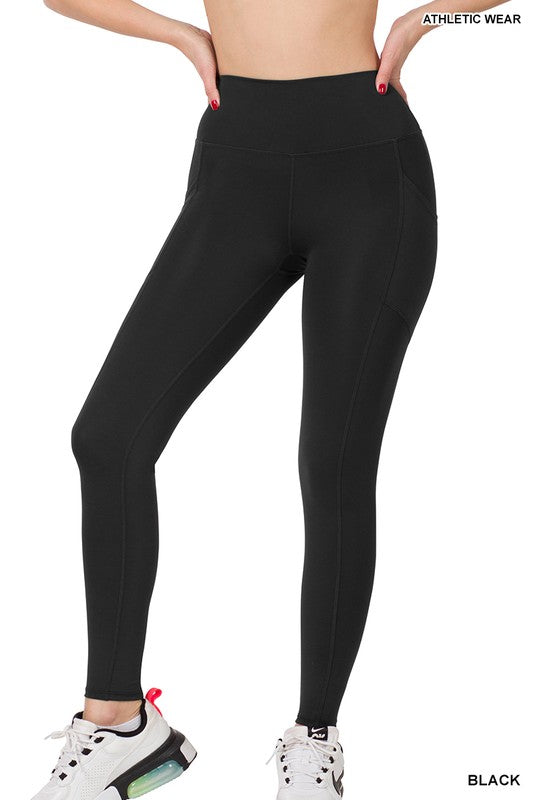 Model showing lower torso with black polyester and spandex athletic wide waistband full length leggings with pockets to fit your phone inside.